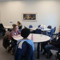 Photo of an alumna talking with two students at the 30 Minute Mentors Event